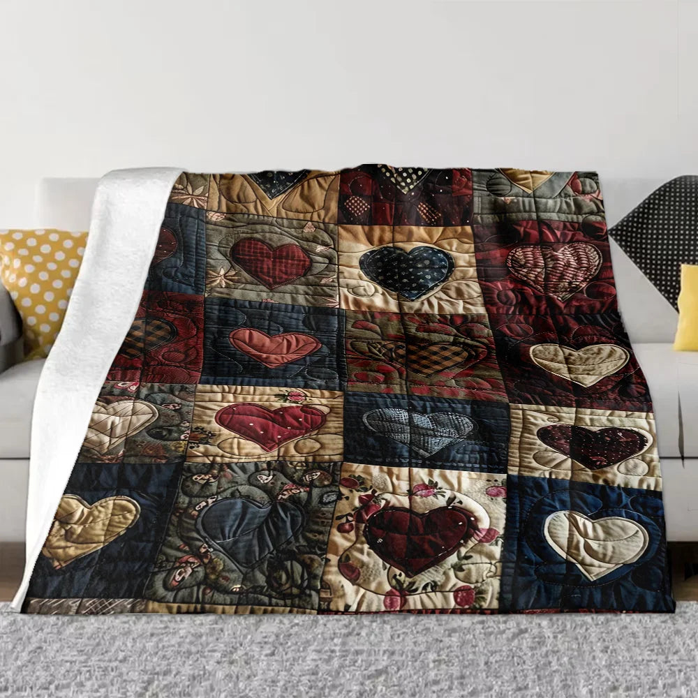 A quilted flannel throw blanket featuring a patchwork design with various heart patterns in deep reds, blues, and browns.