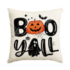 A pillow featuring a black and orange Halloween design with spooky text and a pumpkin face.