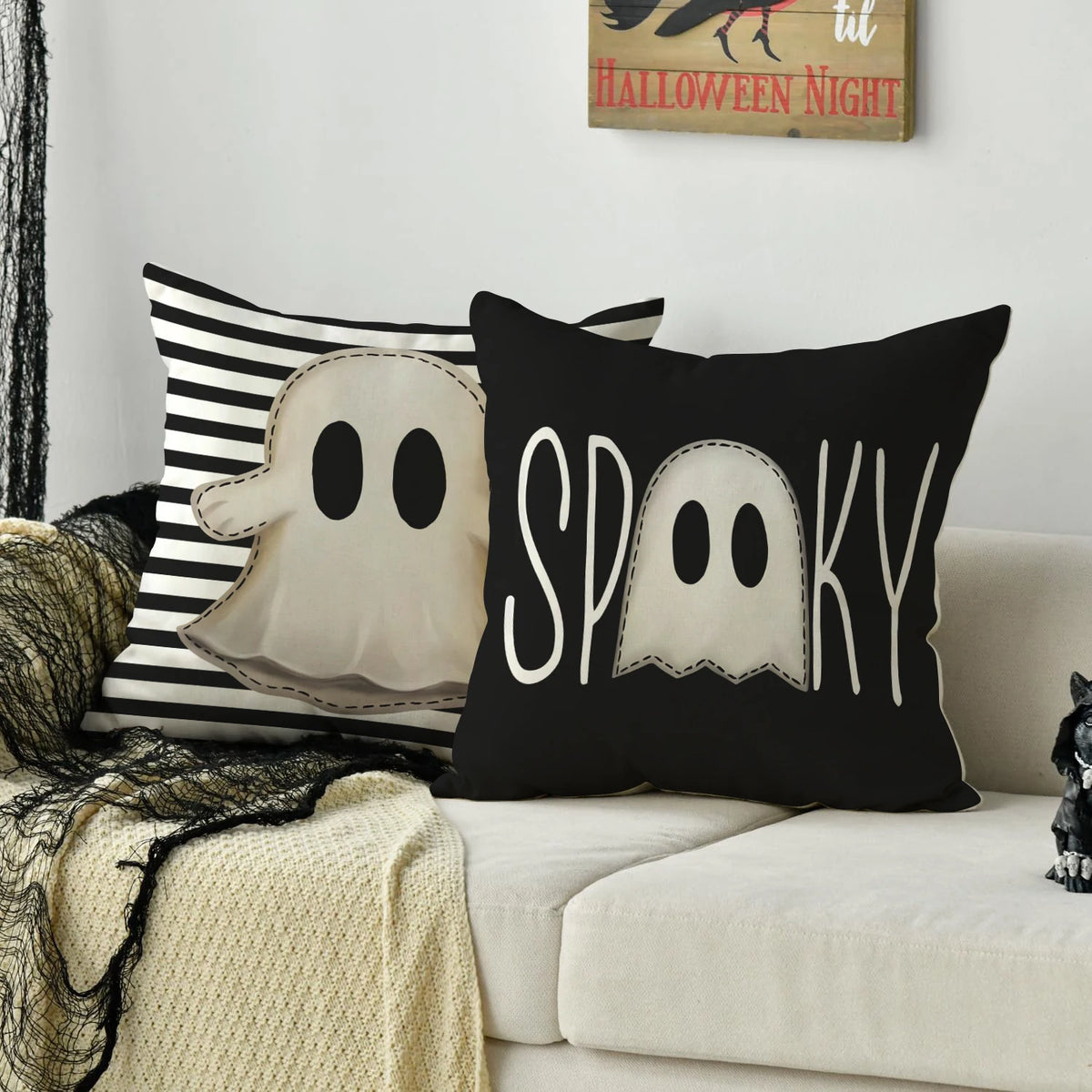 A set of four black and white cushion covers featuring Halloween designs like a ghost, pumpkin, and skull.