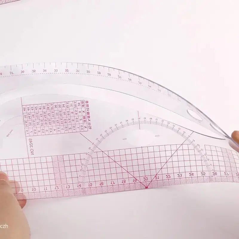 A clear plastic precision sewing ruler set showing a French curve template and measurement markings on a white surface.