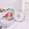 A set of colorful pearl head pins for sewing and crafting displayed on a white surface.