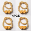 A set of four golden-colored magnetic curtain tiebacks, each featuring a wooden block design.