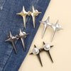 A collection of adjustable star-shaped jean buttons in gold and silver metal on a denim background.
