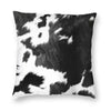 A square cushion cover featuring a black and white cowhide print.