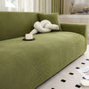 A lime green stretch jacquard sofa slipcover in a modern living room setting.