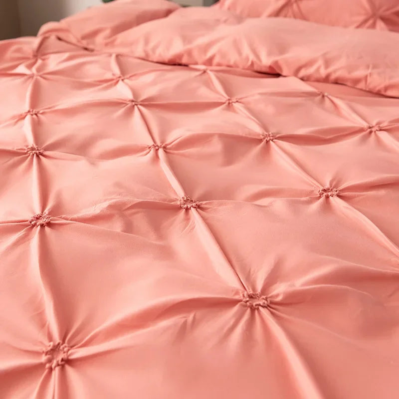 Close-up of a pink quilted bedding set featuring diamond stitching and gathered fabric.