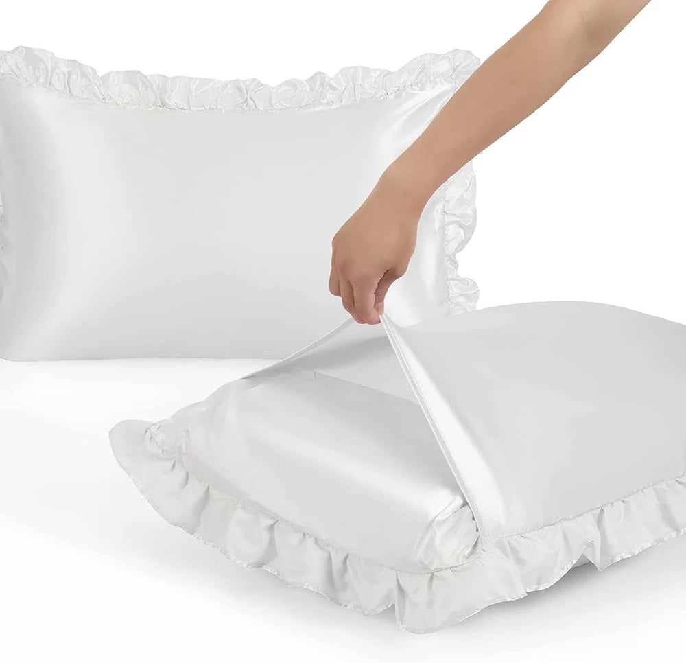 A hand is opening a white ruffled satin pillowcase, showing the silky envelope closure.