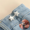 Silver star-shaped adjustable button clips attached to a denim fabric