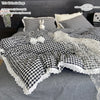 A plaid duvet cover and pillowcase set featuring black and white checkered fabric with lace trim.