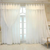 White sheer double-layer curtains with gathered fabric framing a tall arched window.