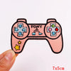Pink embroidered letter iron-on patch shaped like a retro game controller with colorful buttons and stars.