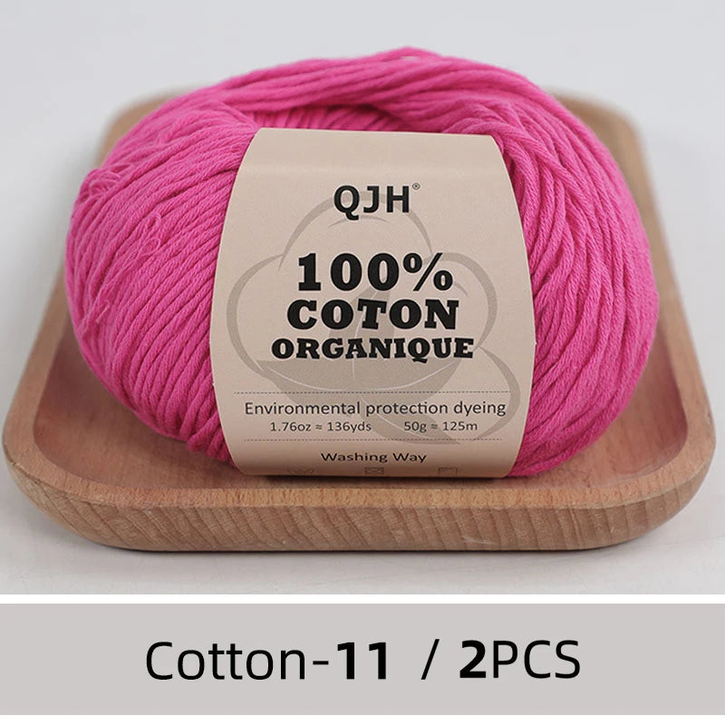 Pink organic cotton yarn skein with a label showing environmental protection dyeing details