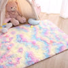 A fluffy, multi-colored shag rug with pink, yellow, and blue hues is displayed in a bright room.