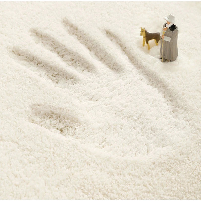 A paw print in white snow or fluff with a small dog and a person standing nearby.