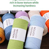 Spools of hollow cotton yarn in various shades including green, blue, and orange.