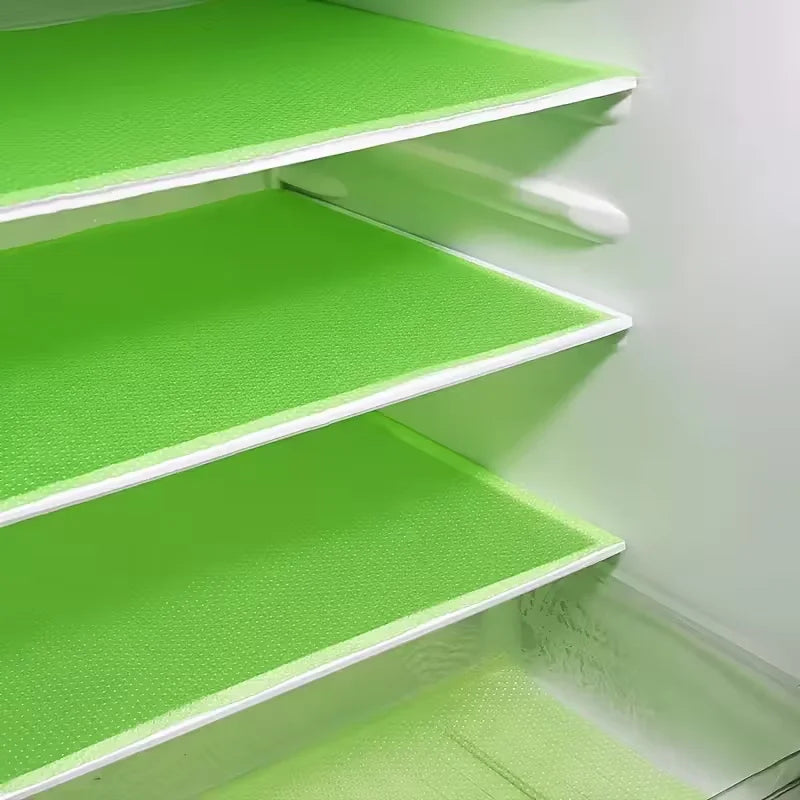 A set of four bright green, non-slip shelf liners for a refrigerator or freezer.