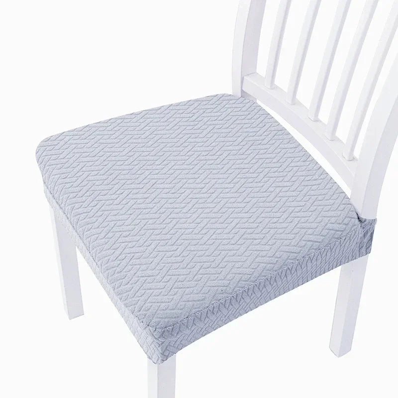 A white wooden chair with a light blue quilted seat cover.