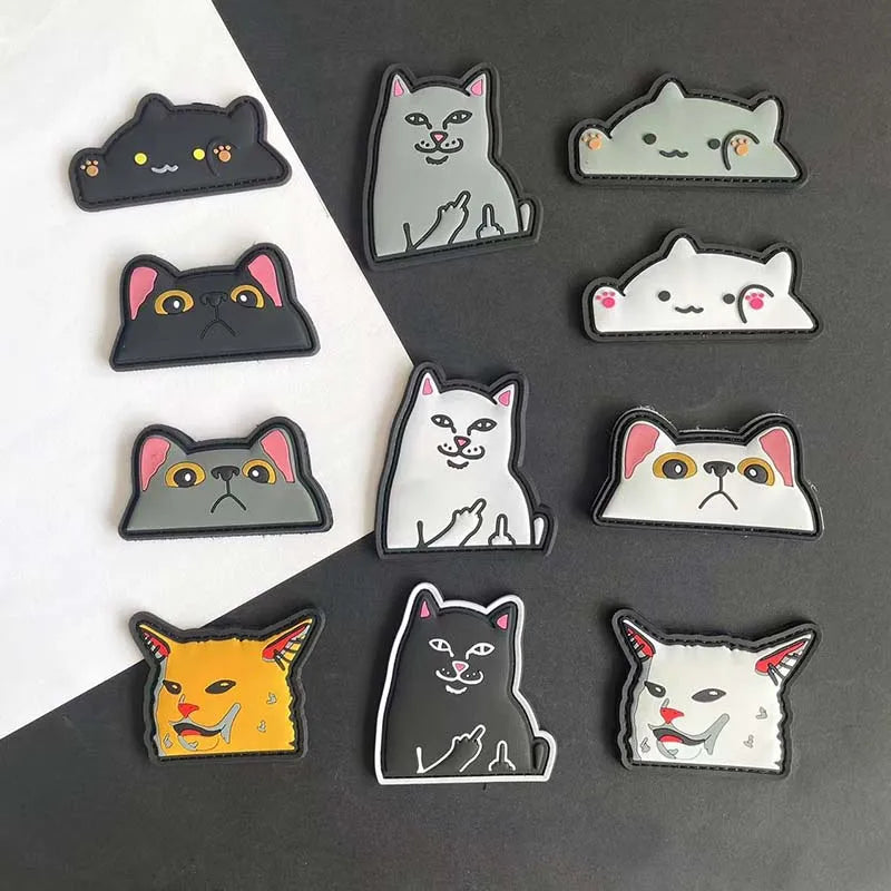 A collection of embroidered tactical patches featuring various funny cat faces and expressions.