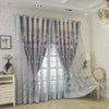 Gray vintage floral blackout curtains hanging in a bright room with sheer overlay.