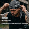 A man is adjusting a black paisley bandana durag headwrap for motorcycle riding.