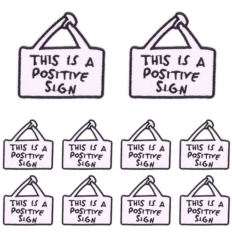 A set of ten embroidered letter Slogan applique patches for DIY clothing featuring the text This is a positive sign.