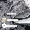 Close-up of a gray and black faux fur rug showing its layers including a thick microfiber, memory sponge interlayer, and non-