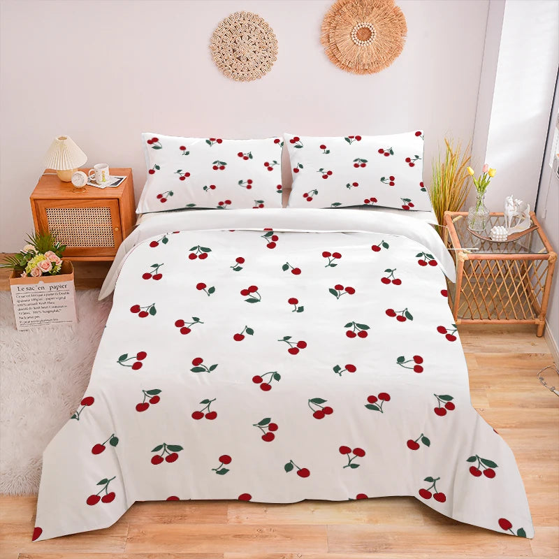 White duvet cover set with a red fruit print featuring cherries and leaves on a bed.