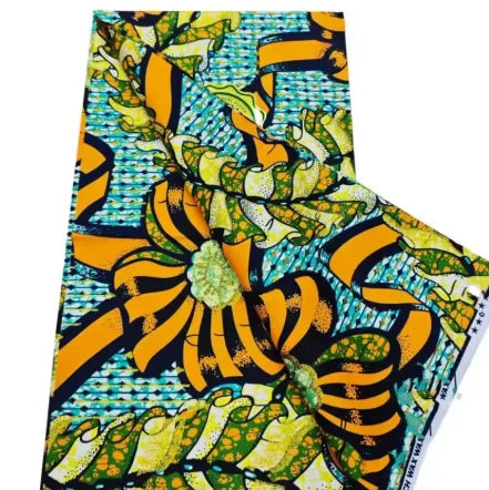 Close-up of an African wax print fabric featuring a vibrant pattern of yellow, green, and blue on a black background.
