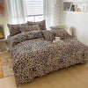 A leopard print duvet cover set with two pillowcases displayed on a bed in a bright room.