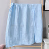Light blue ultra-soft 100% cotton gauze blanket hanging on a wooden rack.