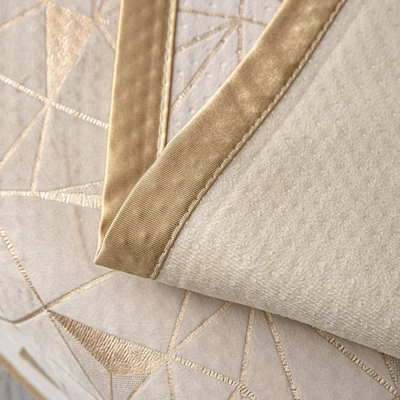 A close-up of a beige luxury chenille sofa cover featuring gold geometric stitching and tan piping.