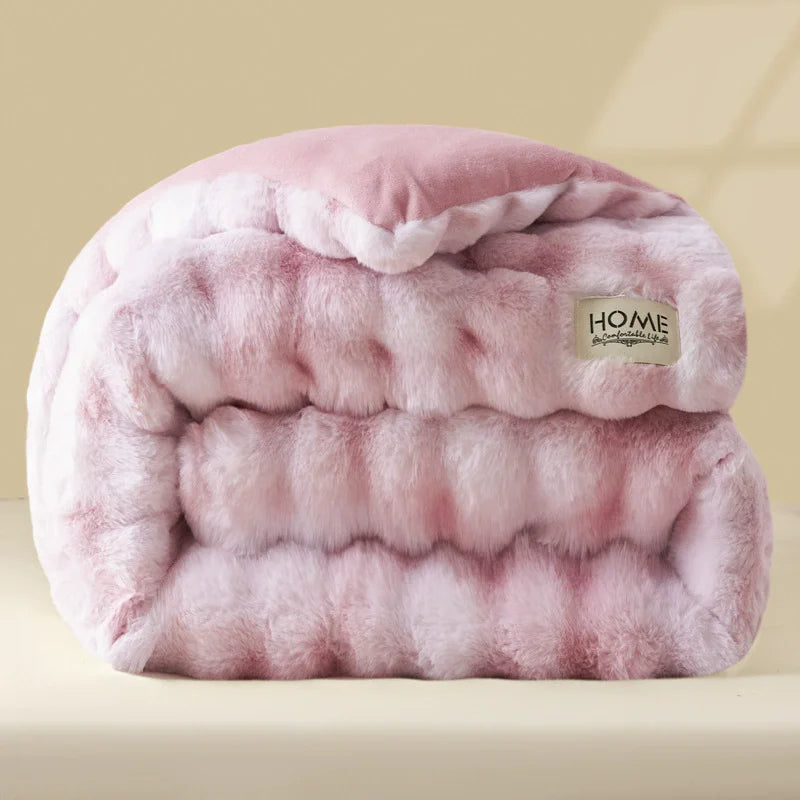 A pink plush rabbit quilt comforter with quilted texture and a small home logo.