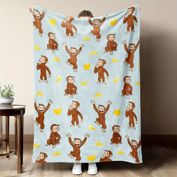 A light blue flannel throw blanket featuring repeating illustrations of Curious George monkeys