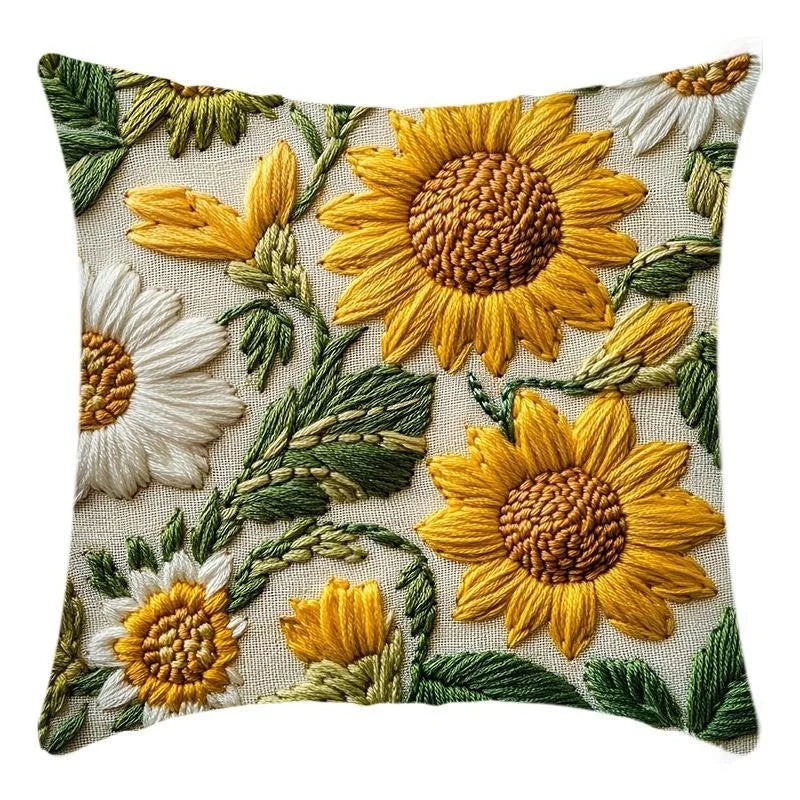 A decorative cushion pillow cover featuring embroidered sunflowers in yellow and white on a natural fabric background.