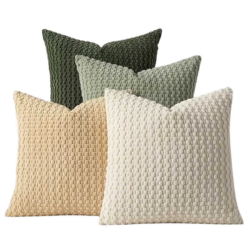 A collection of four textured decorative pillow covers in shades of olive green, sage green, and beige.
