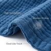Close-up of a navy blue pure cotton gauze throw blanket showing features like high breathability, moisture wicking, and cloud