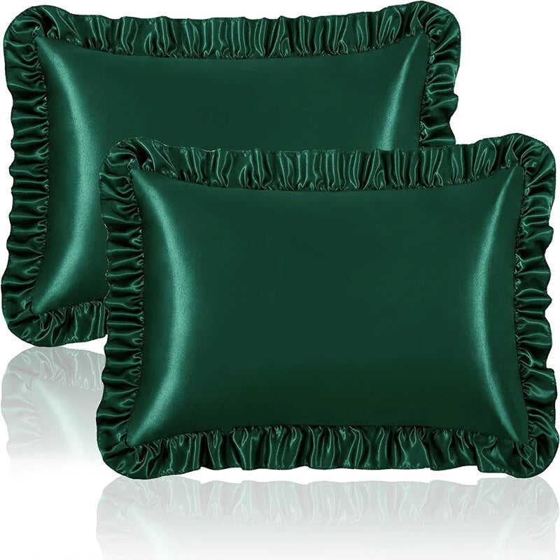 A set of two dark emerald green ruffled satin pillowcases with silky envelope closures.