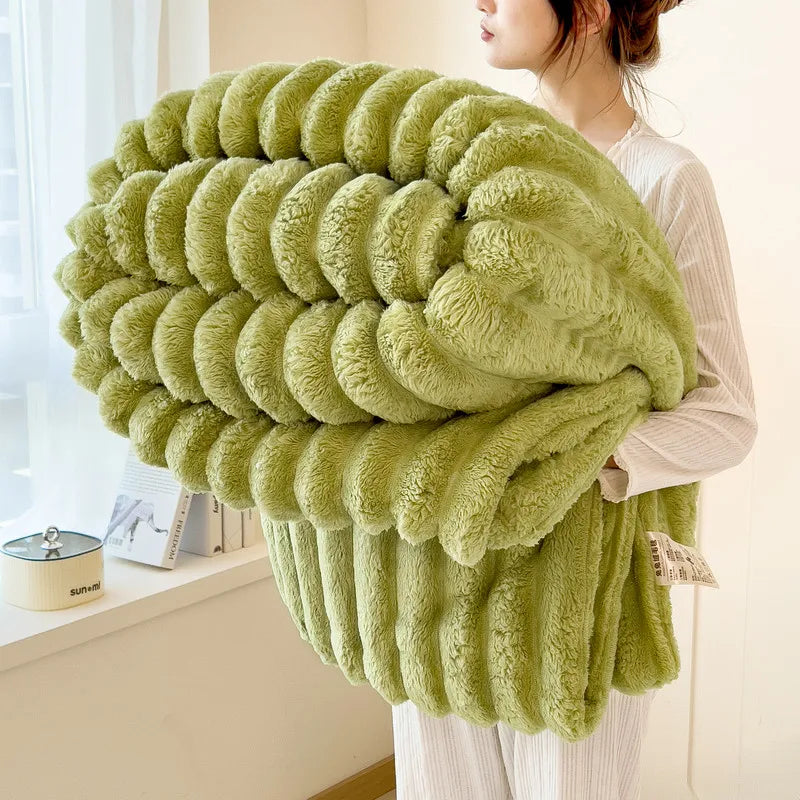 A fluffy, olive green blanket with a ribbed texture is displayed next to a person indoors.