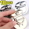 A hand holds a gold metal twist lock for bags and cases, showing the detail of the small locking mechanism.