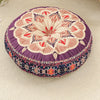 A round bohemian tatami cushion with intricate floral patterns in purple, cream, and red embroidery.