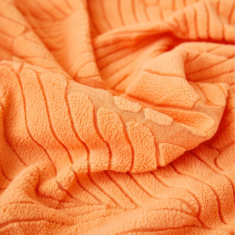 Orange textured fabric of a leaf jacquard stretch sofa cover with anti-slip backing