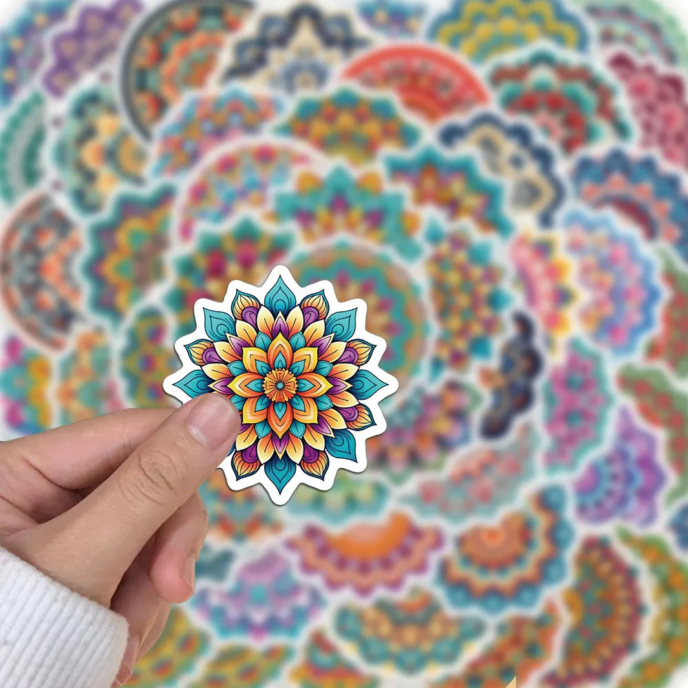A hand holds a colorful mandala graffiti sticker with intricate floral patterns against a patterned background.