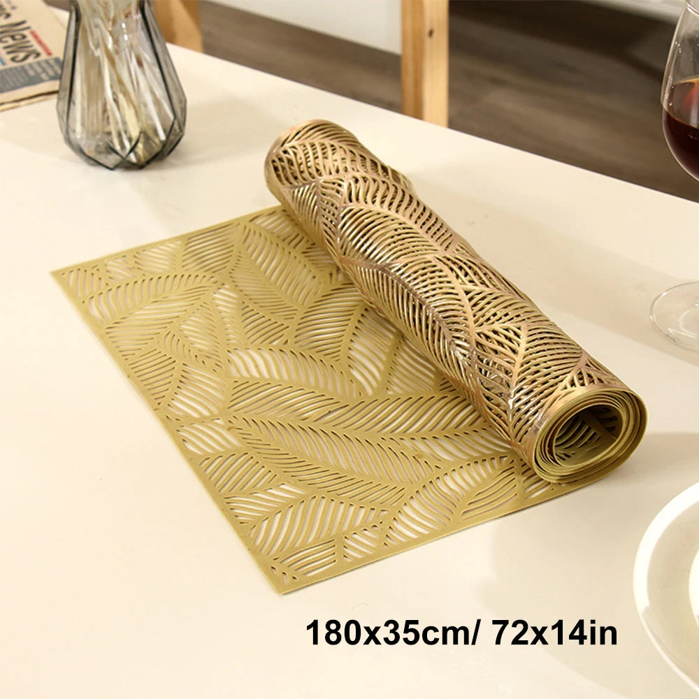 A golden woven table runner with a leaf pattern rolled up on a light surface.