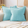 A teal striped corduroy lumbar support pillow cushion resting on a light-colored sofa.