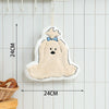 A cute cartoon dog shaped hanging hand towel in beige and white against a light tiled background.