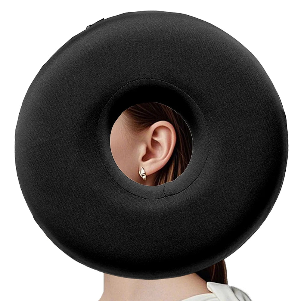 A black comforting ear piercing pillow is shown against a white background.