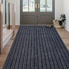 A long, narrow runner rug with vertical black and white stripes placed on a light wood floor.
