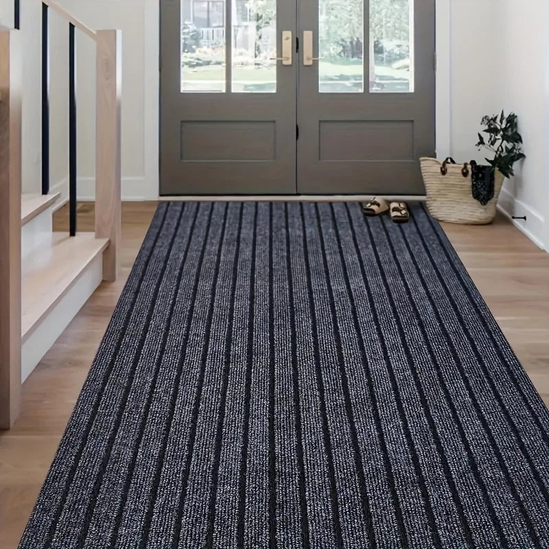 A long, narrow runner rug with vertical black and white stripes placed on a light wood floor.
