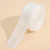 Roll of white self-adhesive hem tape for fabric repair and shortening