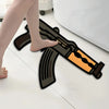 A creative gun-shaped rug is shown on a white floor next to a bare foot.